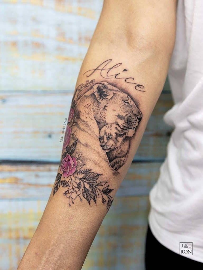 腕に名前のあるバラのタトゥー