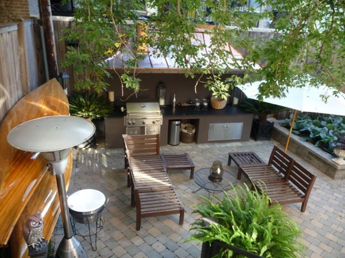 Pardoseală din piatră naturală cu bănci și zonă pentru grătar Colț de grătar și zonă de lounge cu șezlonguri din lemn