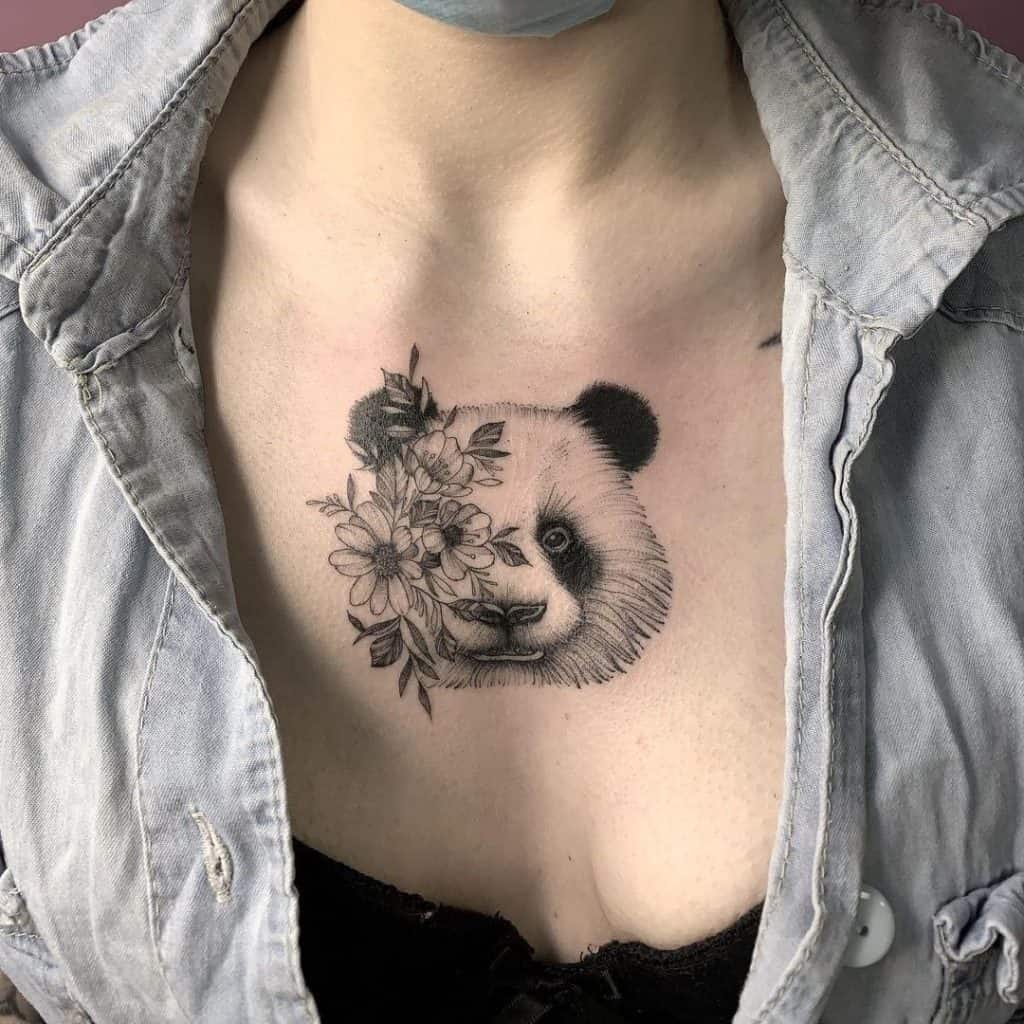 Tatuagem de bebê panda no peito com flores