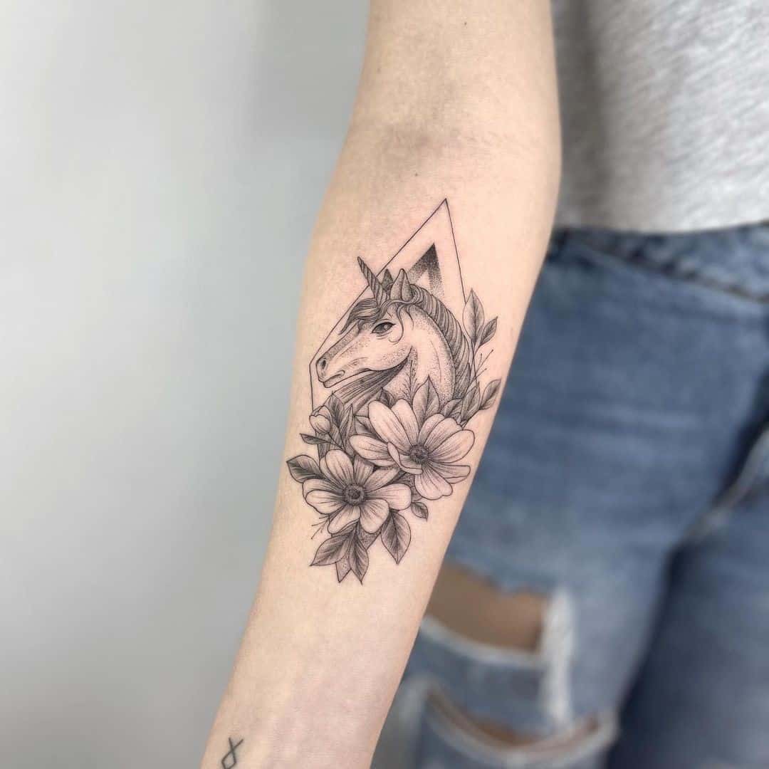 Tatouage de licorne noire avec des fleurs
