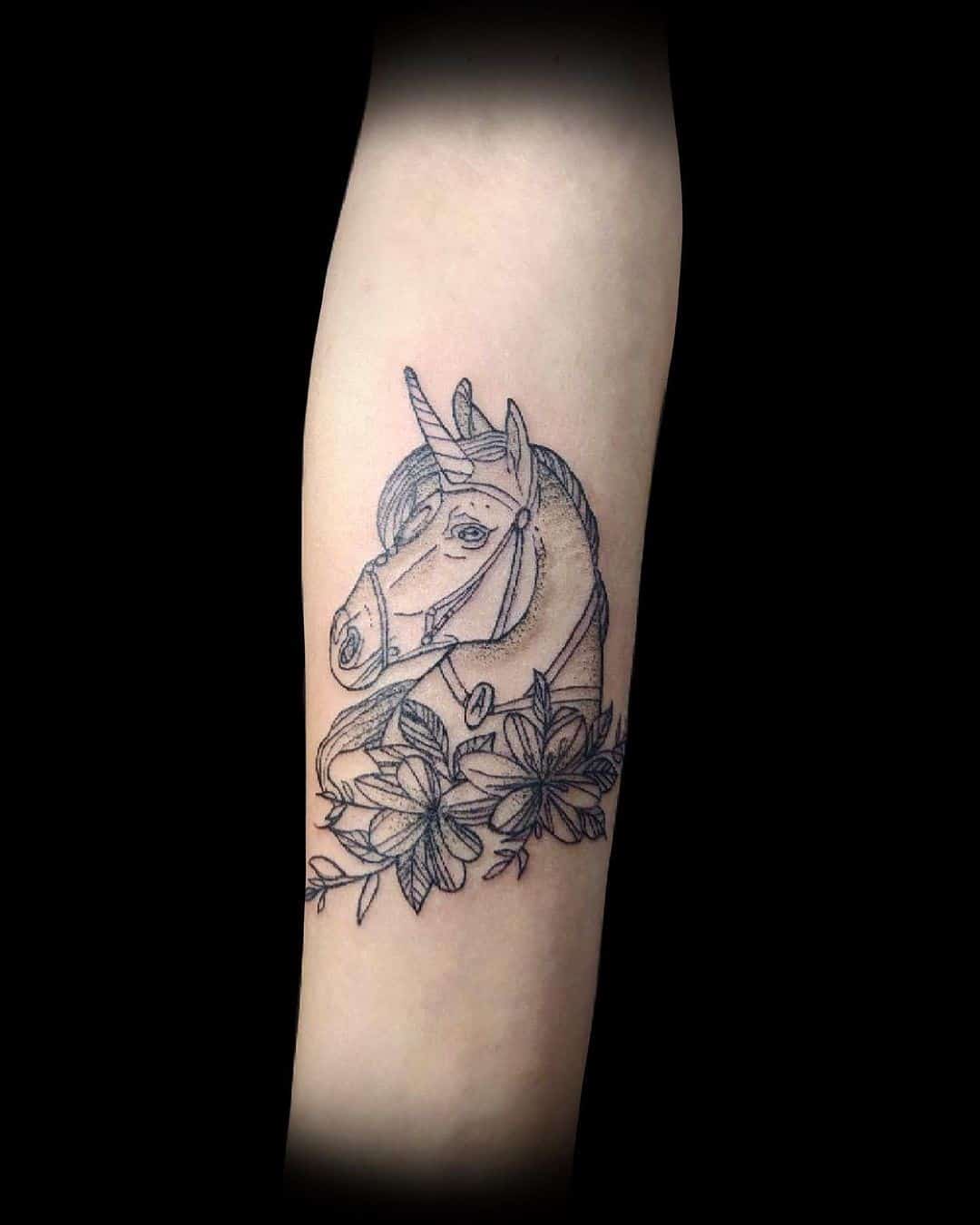 Tatouage de licorne sombre avec des fleurs