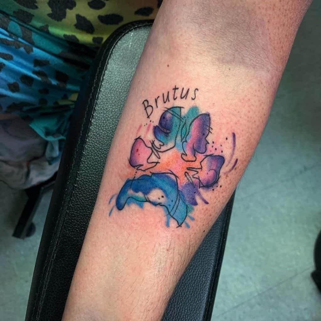 Tatuagem de pata de cachorro em aquarela no braço