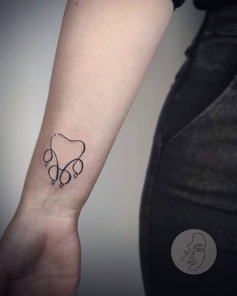 Tatuagem minimalista de pata de cachorro no braço