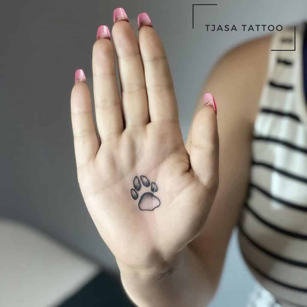 Tatuagem de pata de cachorro na palma da mão