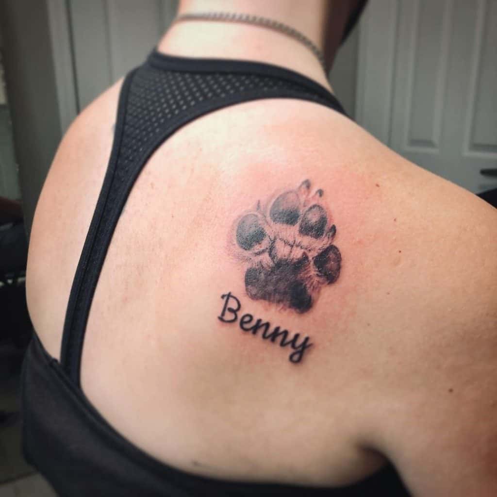 Tatuagem de pata de cachorro com o nome de Benny