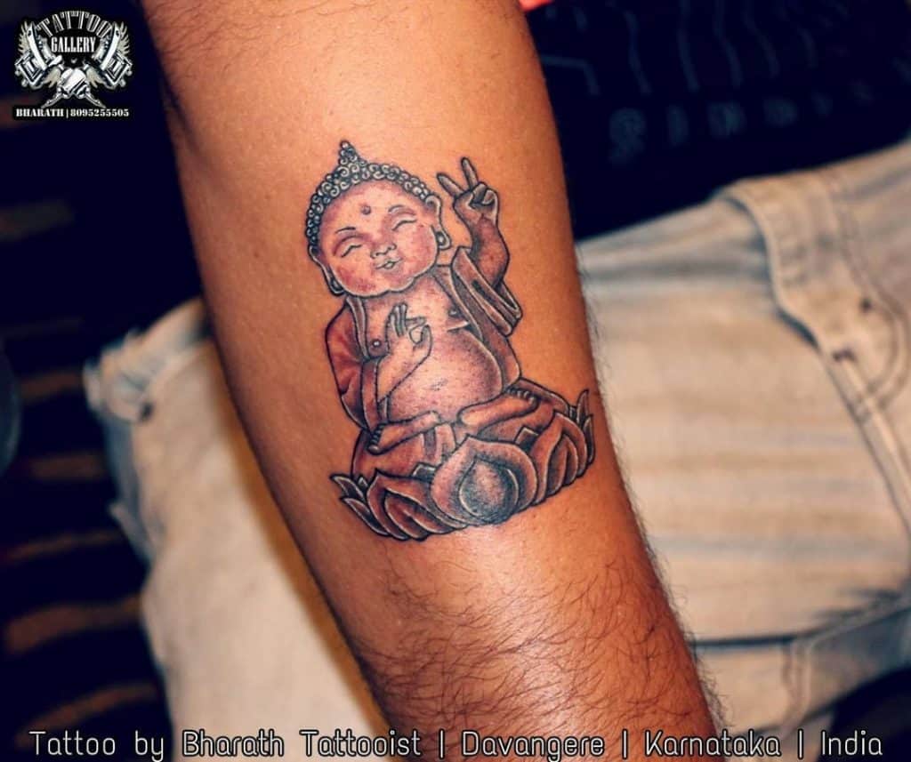 Pequena paz mostrando o Buda tatuado
