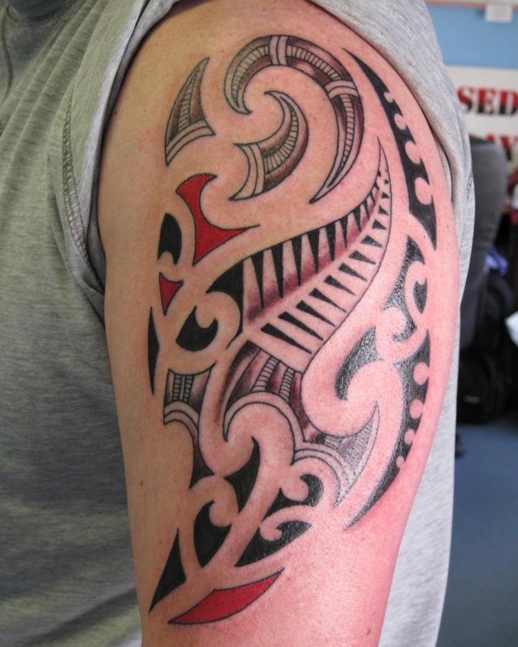 Tatuaj tribal pe brațul superior cu accente roșii Tatuaj braț superior manieră accente roșii tribale