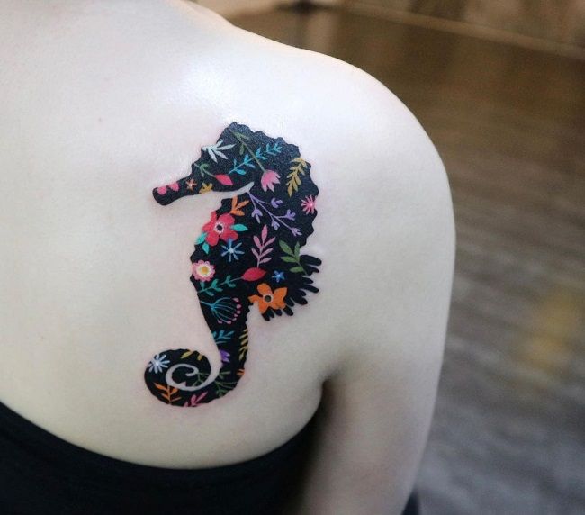 黒をテーマにした花のタツノオトシゴのタトゥー