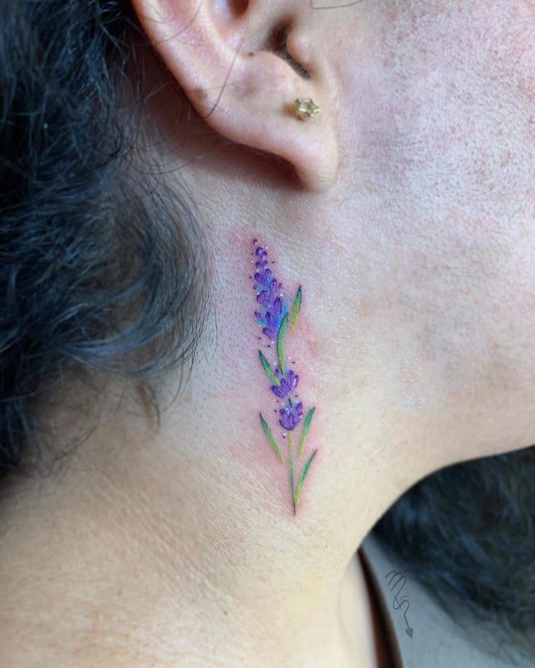Uma tatuagem de lavanda atrás da orelha
