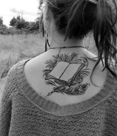 Livre ouvert avec plume de paon et tatouage de feuilles sur le dos d'une femme