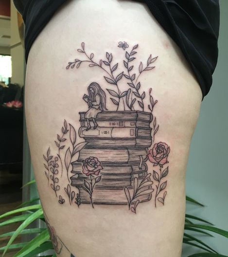 Pile de livre avec des fleurs, des feuilles et une fille assise dessus tatouage sur la cuisse.