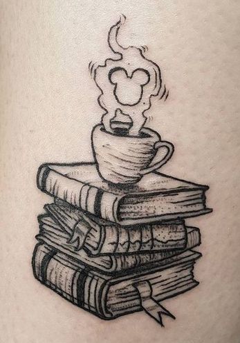 Pile de livres ayant une tasse dessus et tatouage de fumée Micky Mouse.