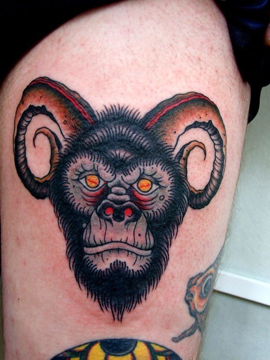 Macaco ousado com tatuagem de chifres na perna