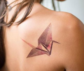 Origami gervės tatuiruotė ant moters nugaros