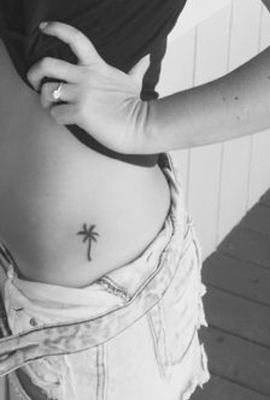 Palmės tatuiruotė ant merginos juosmens