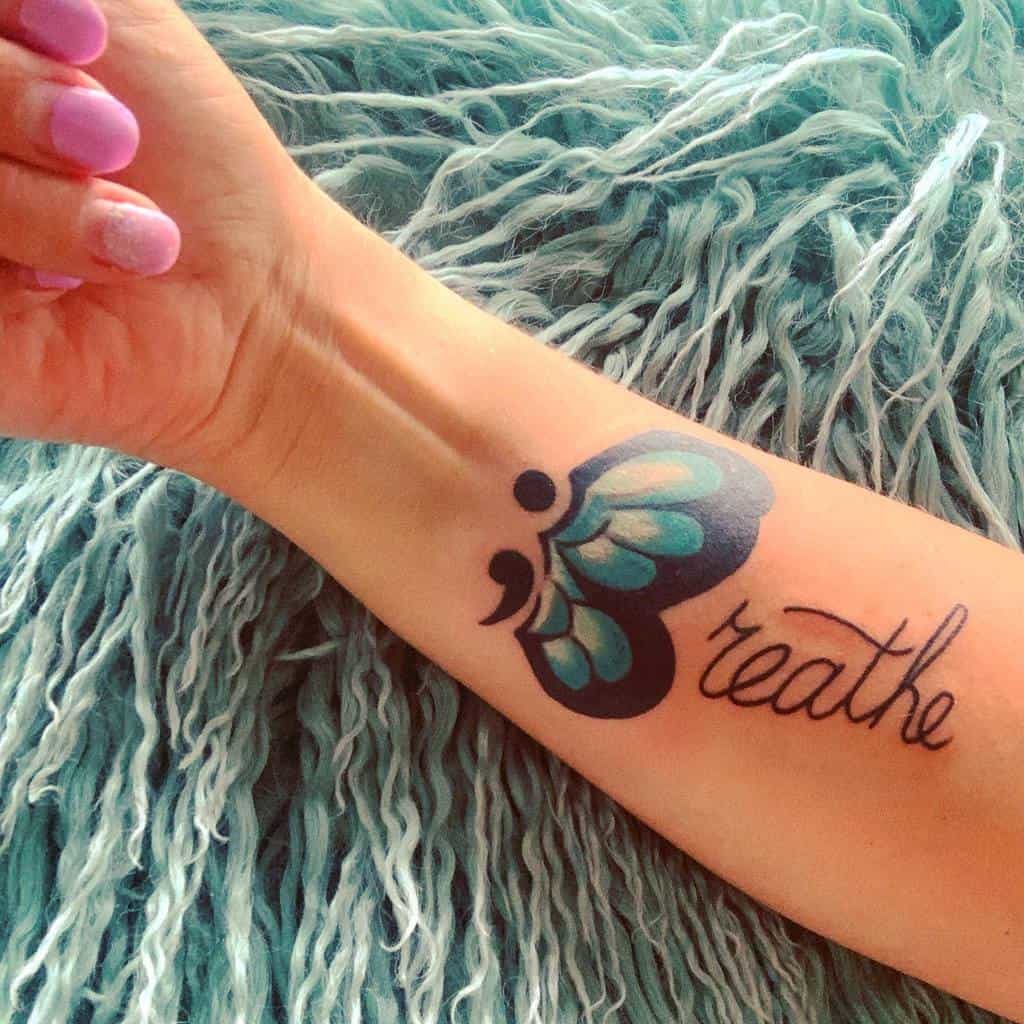 Plavo -crna tetovaža sa zarezom i leptirom pri ruci