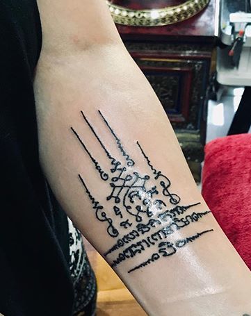 Le pouvoir représenté par le tatouage de Na Maha Samred sur la main.