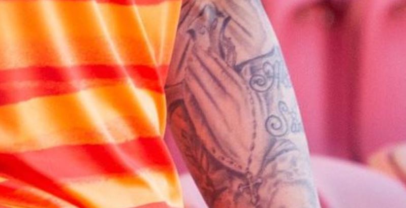 Andres rezando as mãos e tatuagem do rosário