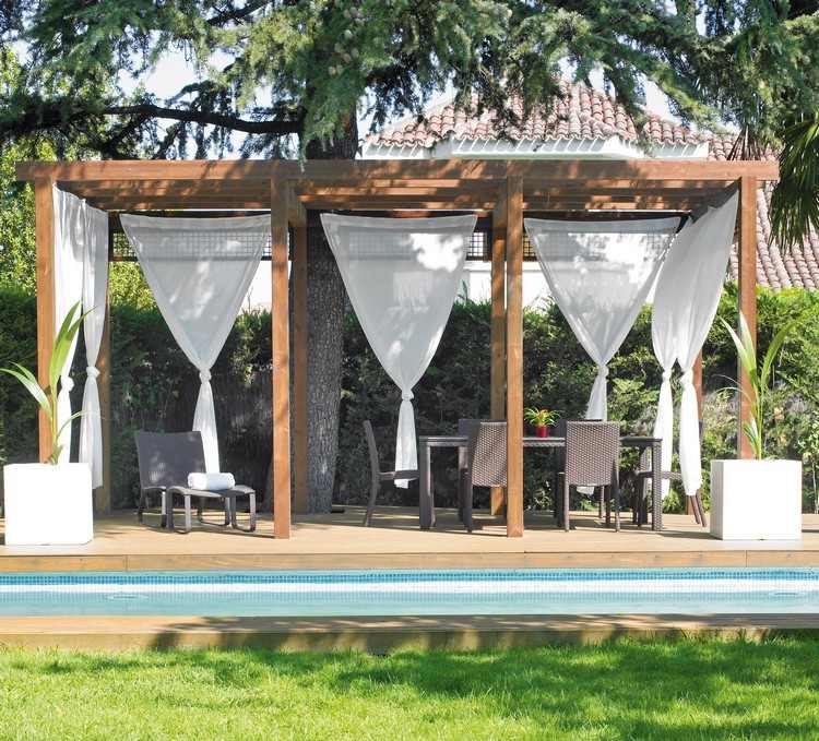 perdele albe înconjoară zona de relaxare acoperită Terasa-acoperita-pergola-din-lemn-perdele-albe-mobilier-din-ratan