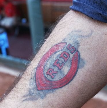 Tatuaggio del logo dei Cincinnati Reds sul braccio destro di Charlie Sheen