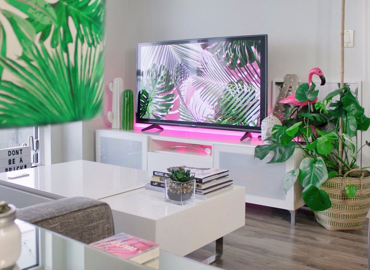 Benzi LED roz lipite de bufet în spatele televizorului din sufragerie