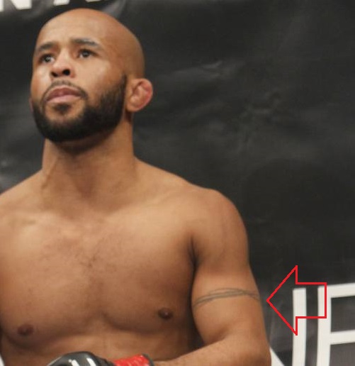 Demetrious Johnson kairės rankos juostos tatuiruotė