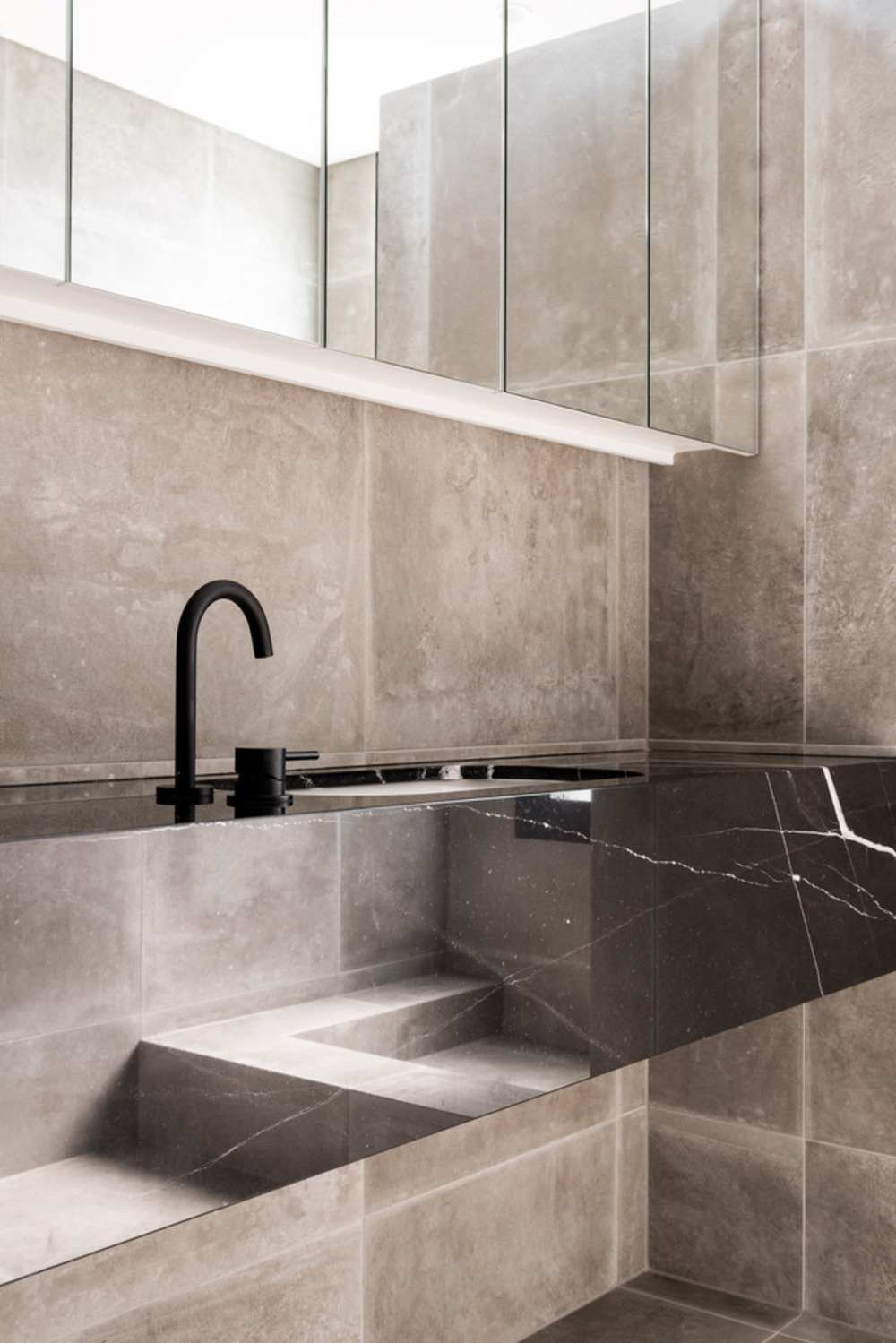 gresie în baie în combinație cu un lavoar din marmură cu un robinet negru