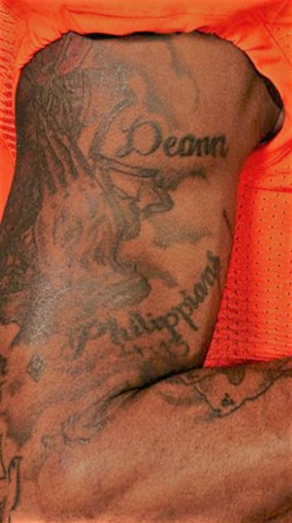 Deshaun Mains en prière et tatouage croisé