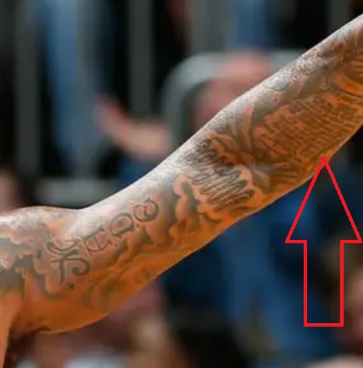 DeShawn scrive sul tatuaggio del braccio
