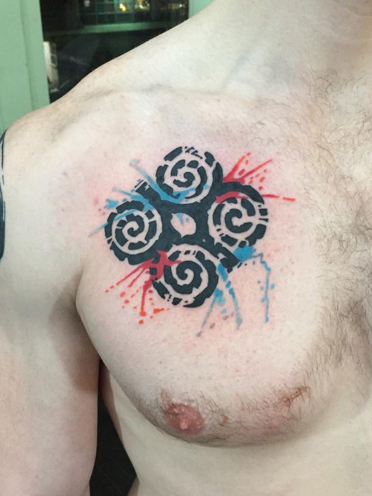 Tatuaggio Adinkra di colore rosso e blu sul petto