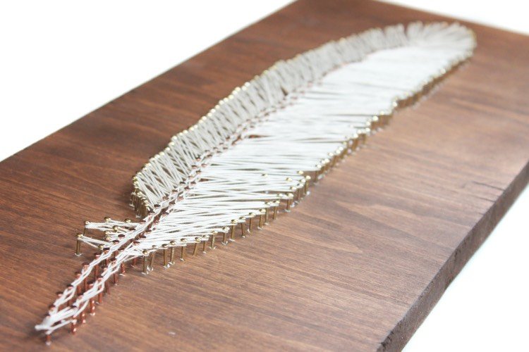 Model de fir de pene cu cuie din alamă și cupru fire-poze-cuie-pene-alb-fir-pe-lemn