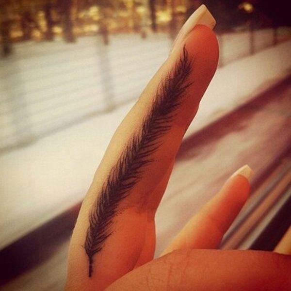 指の上の女性のための小さな羽のタトゥー