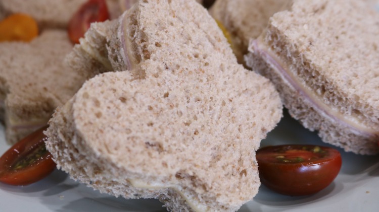 sandviș de petrecere decupat în formă de fluture și aranjat într-o farfurie cu roșii