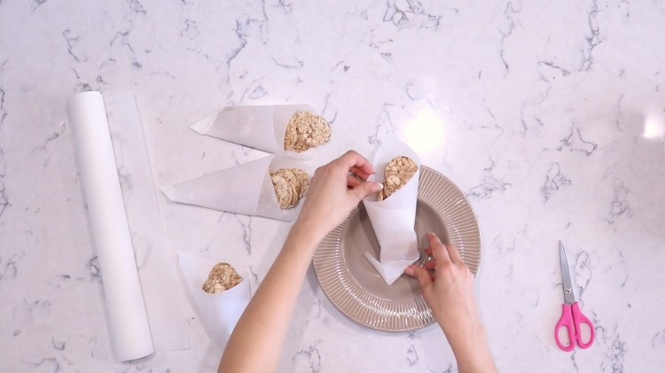 Îndoiți pungile din hârtie de copt pentru petreceri cu mâncarea degetelor și umpleți-le cu chipsuri de legume sau chipsuri de orez