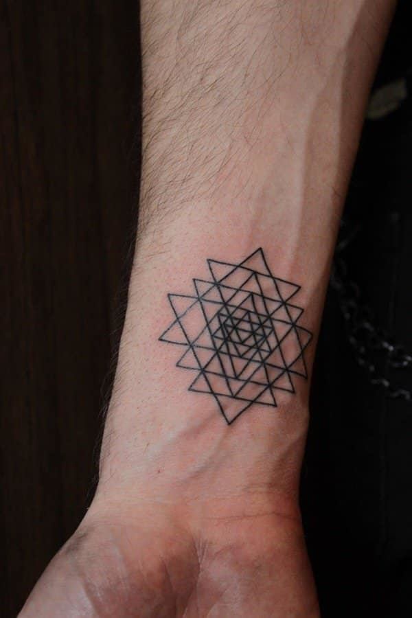 Tatuagem de estrela geométrica para homens no pulso
