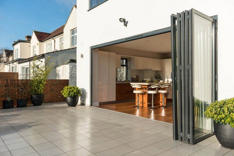 Peretele pliabil cu frunzele ușii împinse împreună Uși pliabile din sticlă pentru deschiderea peretelui pliabil-terasă-către-terasa-exterioară-gresie-plante