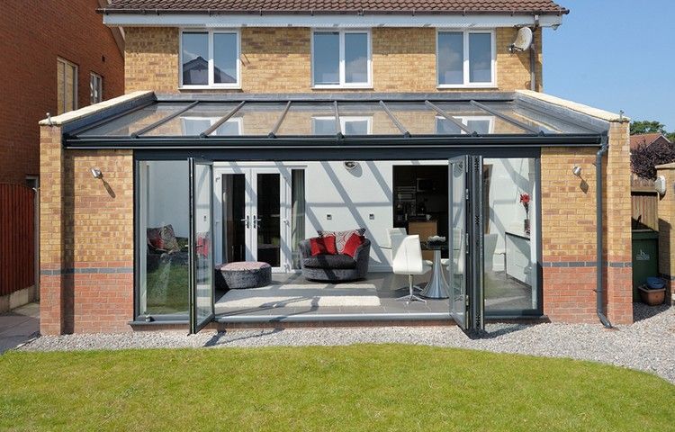 Conservator la casă cu fațadă din cărămidă clincher usi-de-sticla rabatabile-gradina-de-iarna-extensie-acoperis-vitrare-mobilier-interior-living-modern