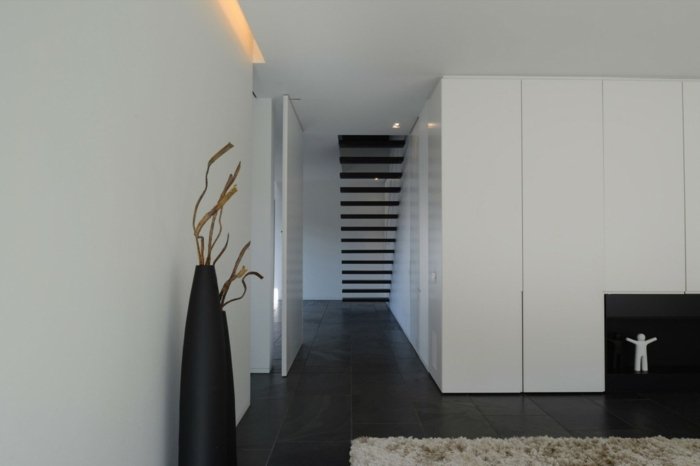 Holul este format din dale de piatră neagră design living hol hol scări șemineu aragaz vază decor