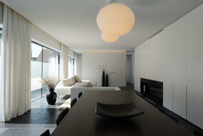 Design cameră de zi cu zonă de luat masa și șemineu living masa de luat masa design canapea neagra semineu alb
