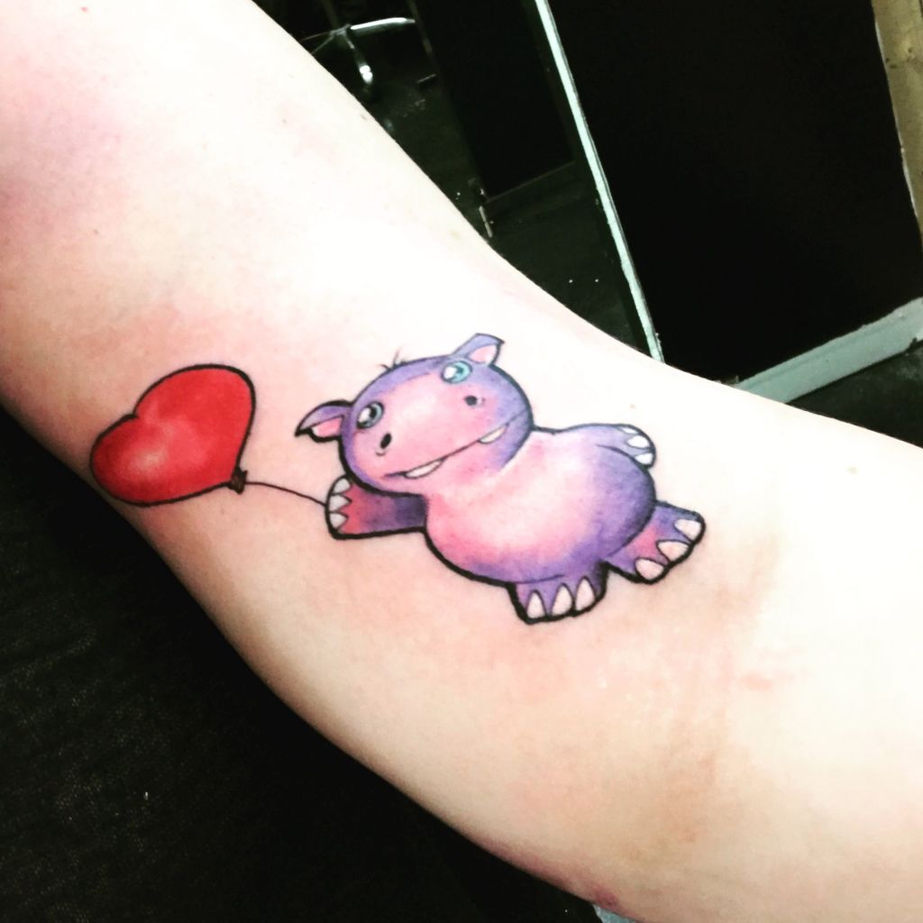 Simpatico cartone animato ippopotamo tatuaggio sul braccio