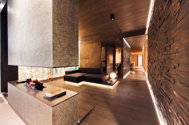 Iluminarea indirectă cu lumină caldă creează o atmosferă modernă și confortabilă Iluminare indirectă-design perete-living-maro-lemn-piatră naturală