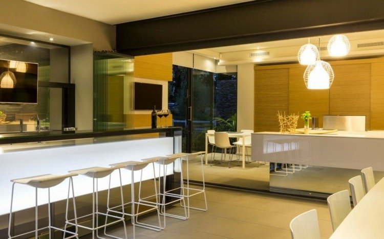 Designul interior natural este evidențiat seara prin iluminare casa materiale naturale iluminat bucatarie bar mobilier contemporan