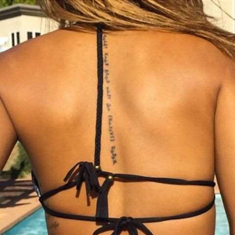 Karrueche Tran écriture arabe sur la colonne vertébrale