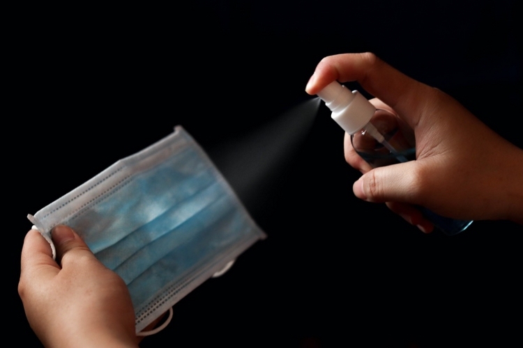 Dezinfectați masca cu alcool în sticla spray