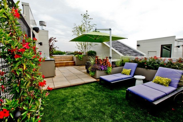 Terasă pe acoperiș cu balcon scaune înclinate plante de gard viu de iarbă artificială Scaune înclinate iarbă artificială plante de gard viu umbrelă de soare zonă de relaxare