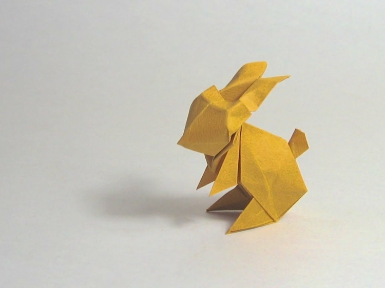 Iepurele stă pe labele din spate origami iepuraș șezând coadă idee de design culoare galbenă