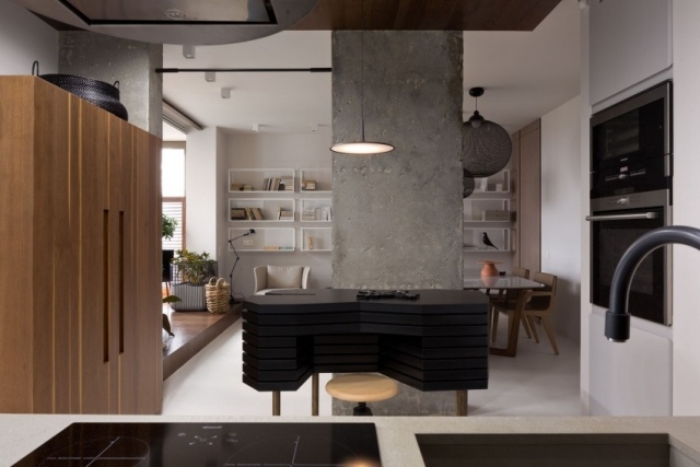 Apartament de designer cu un concept de construcție deschis - pereți de beton ca element de separare Bucătărie amenajată-cu-insulă-design-dulapuri-din-piatră-neagră-despărțitoare-beton