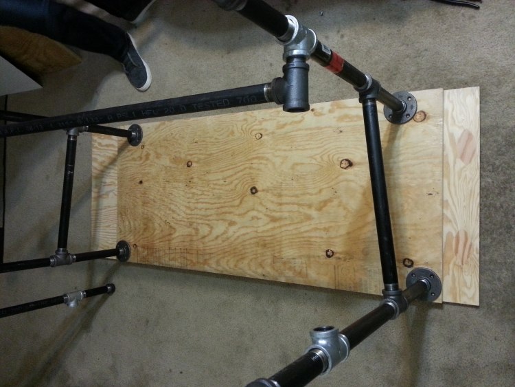 înșurubați placa de lemn la conexiunile conductelor de oțel Construiți-vă propriul birou-idei-instrucțiuni-masă de lucru-placă de lemn-tuburi-mobilier tubular-picioare