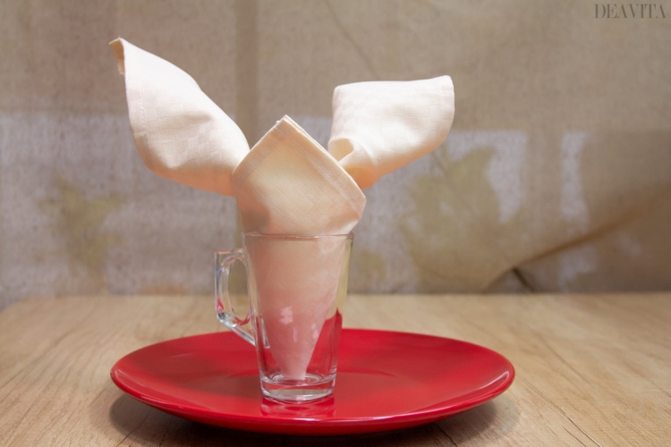 Îndoiți șervețelul de pânză într-un iepure și puneți-l într-un pahar