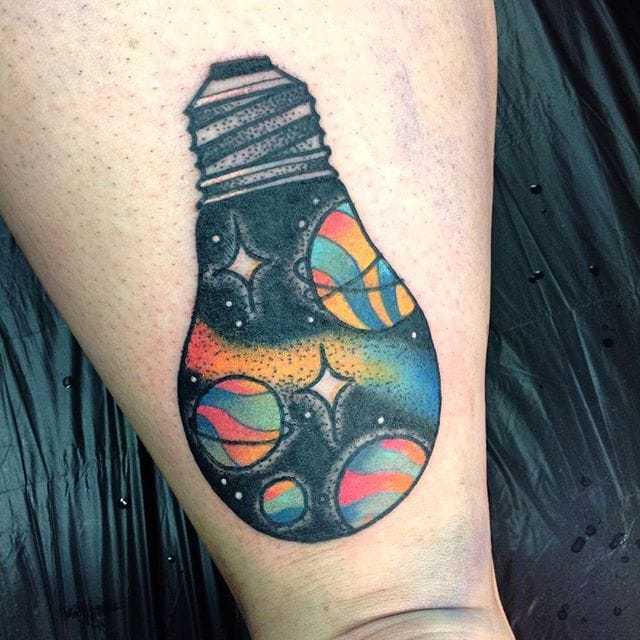 Lampadina Tattoo con sistema solare su gamba